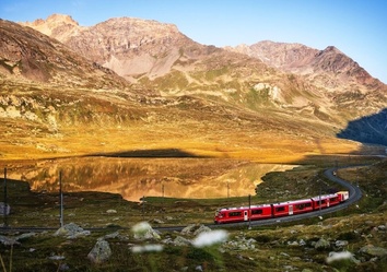 Zug der Rhätischen Bahn entlang des Lago Bianco am Berninapass – Via Albula Bernina, Schweiz